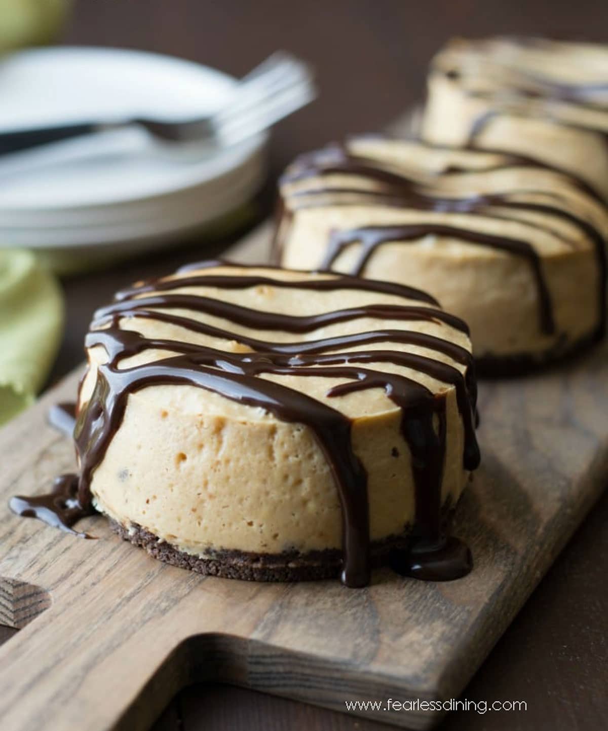A gluten free peanut butter cheesecakes on a wooden tray.