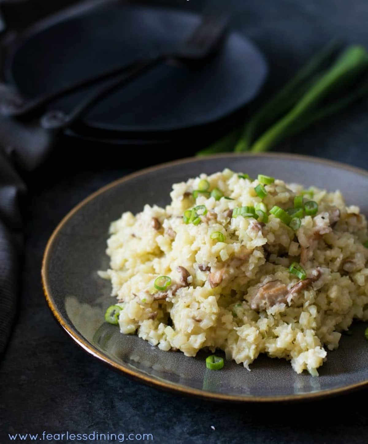 A grey plate filled with riced cauliflower risotto.
