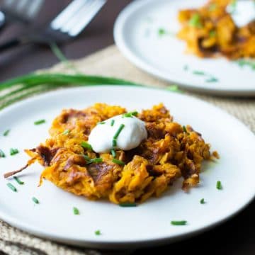 sweet potato waffles on white plates, garnished with sour cream and chives