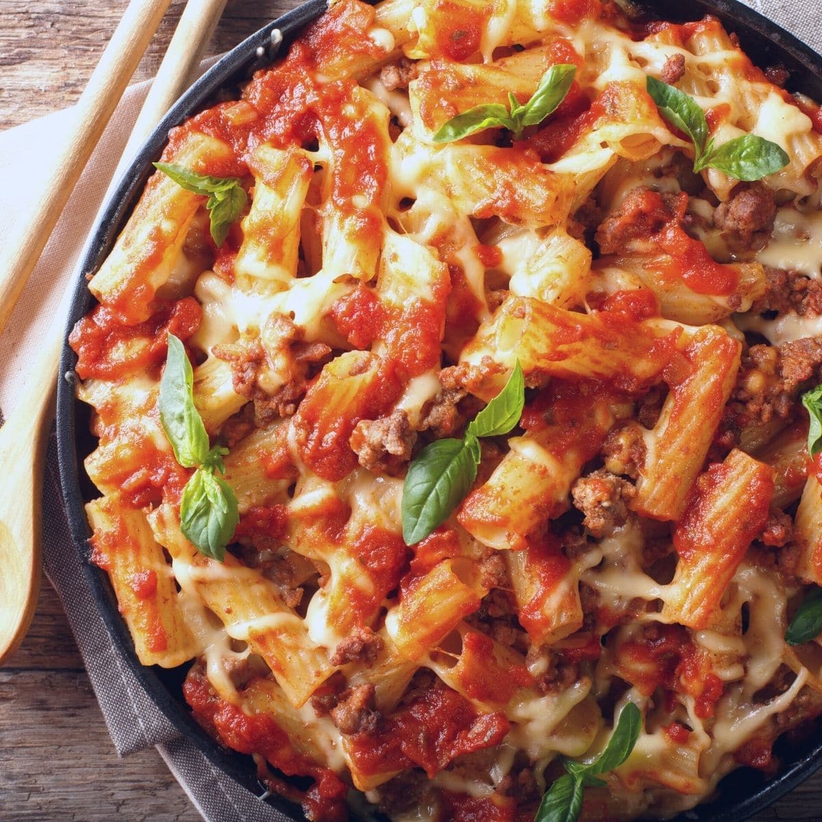 A big bowl filled with ziti with gluten free pasta sauce.