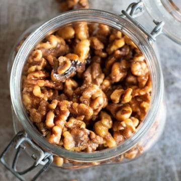 The top view of a jar of cinnamon spiced walnuts.