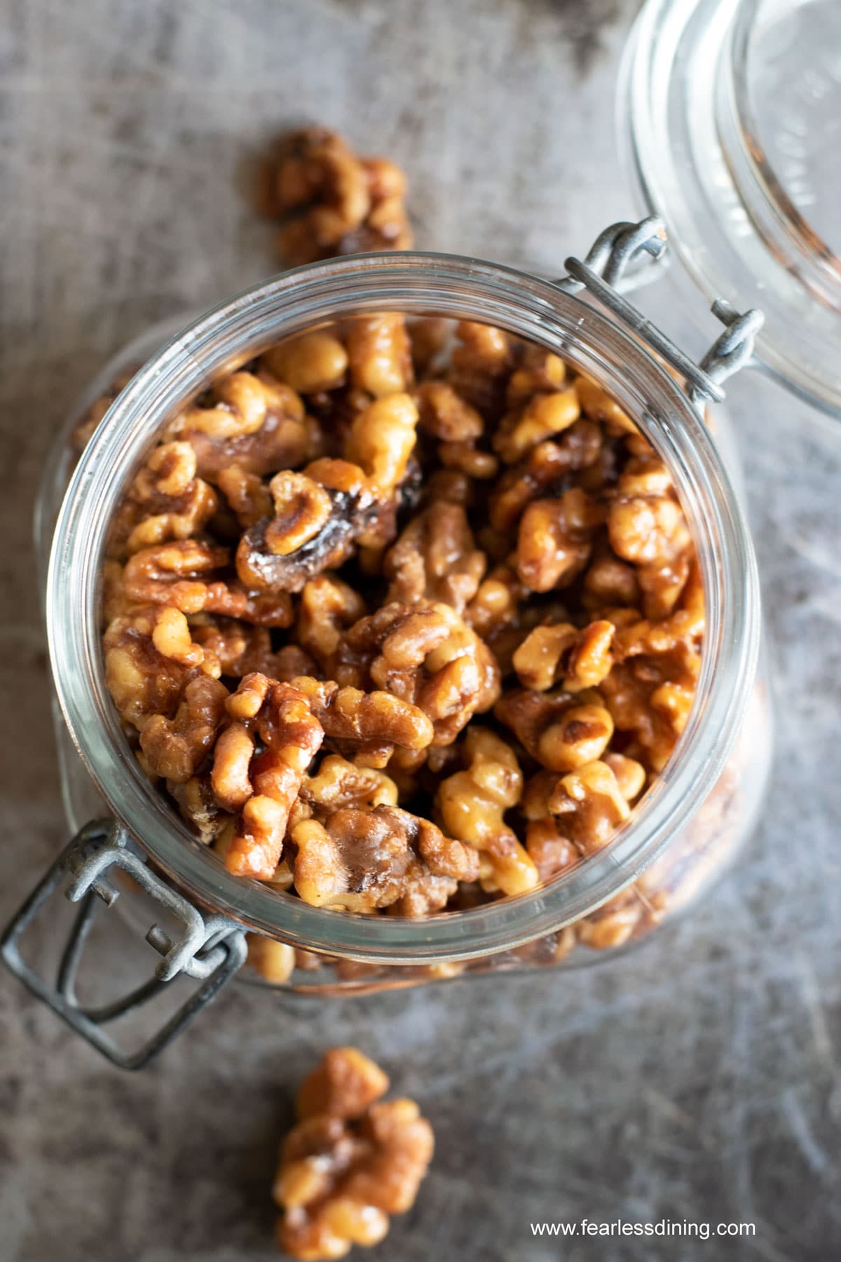 The top view of a jar of cinnamon spiced walnuts.