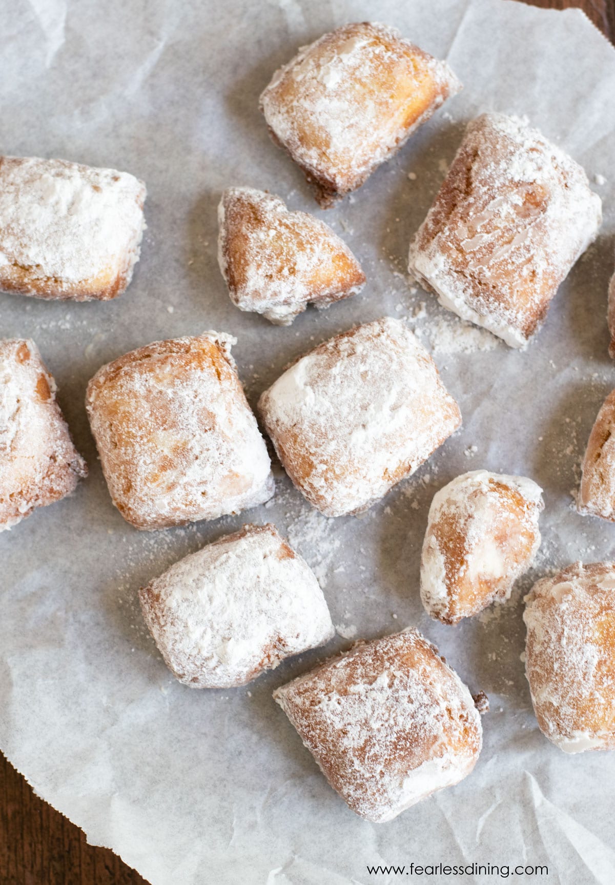 The top view of a bunch of powdered sugar coated beignets.