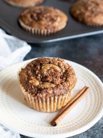 a gluten free cinnamon streusel muffin on a small white plate