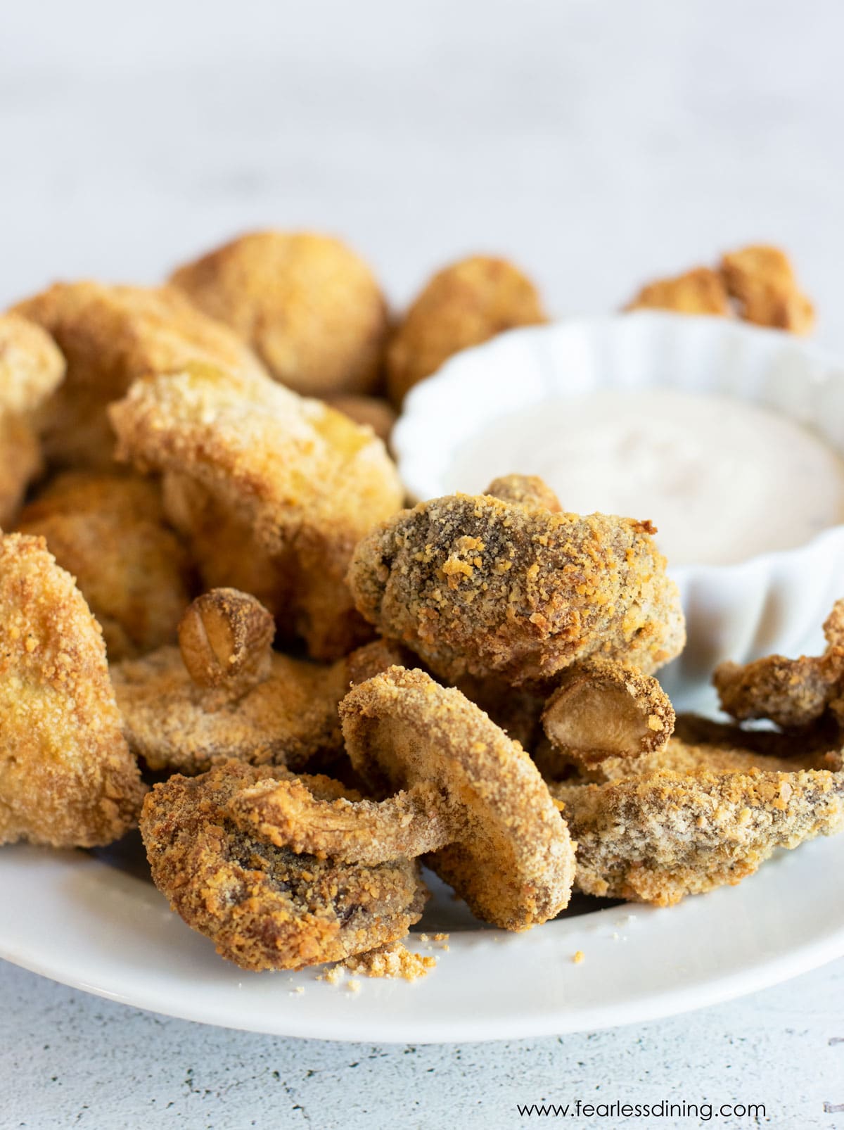 Air fried mushrooms on a plate with dip.