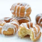 A stack of gluten-free lemon donuts on a white tray.