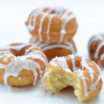 A stack of gluten-free lemon donuts on a white tray.