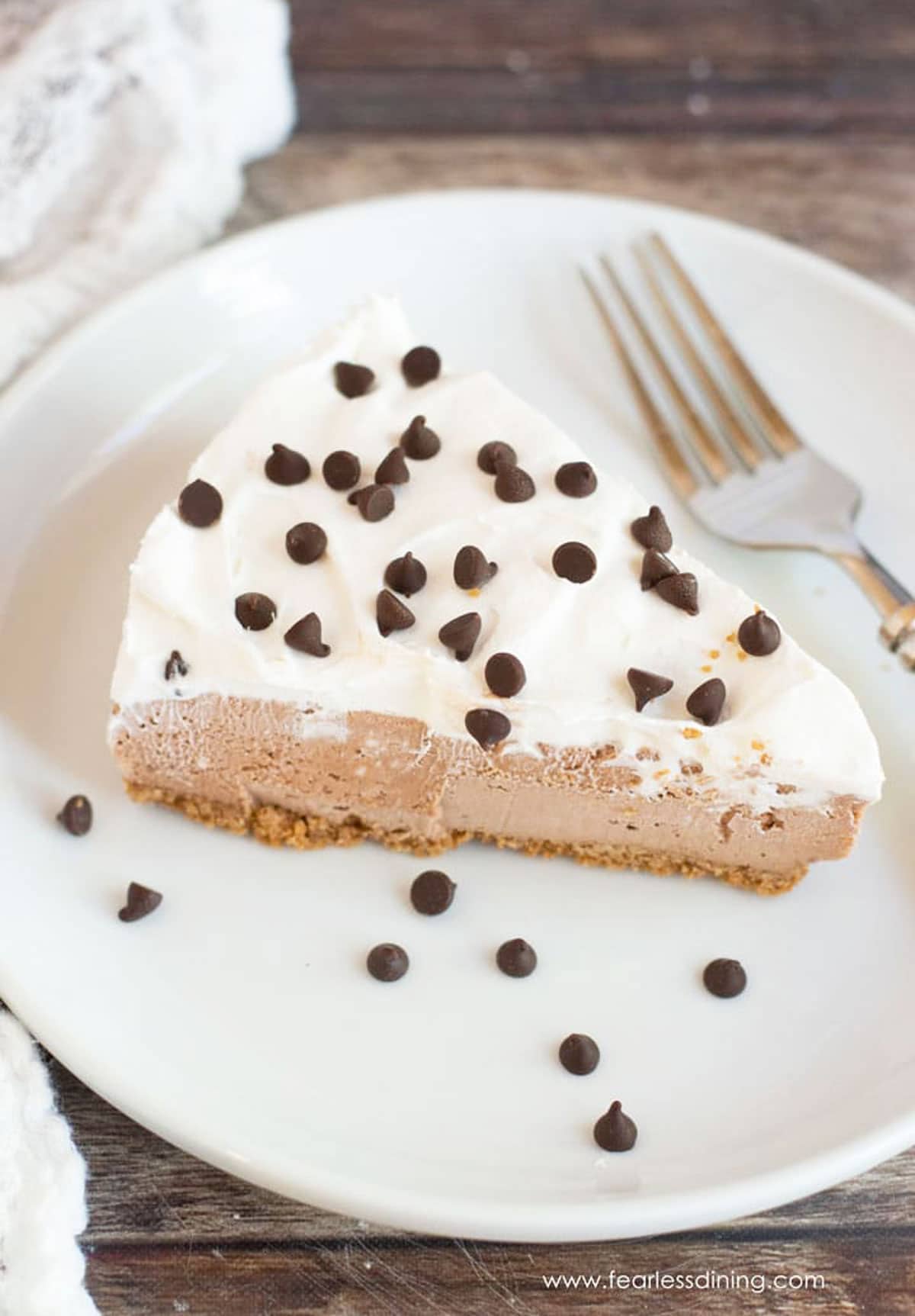 A slice of no-bake gluten free Nutella cheesecake on a small white plate.