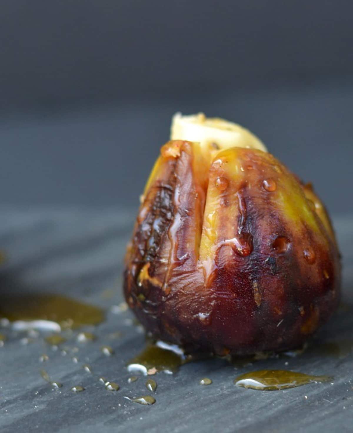 a single brown grilled fig stuffed with brie