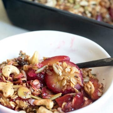 A white bowl filled with plum crisp.