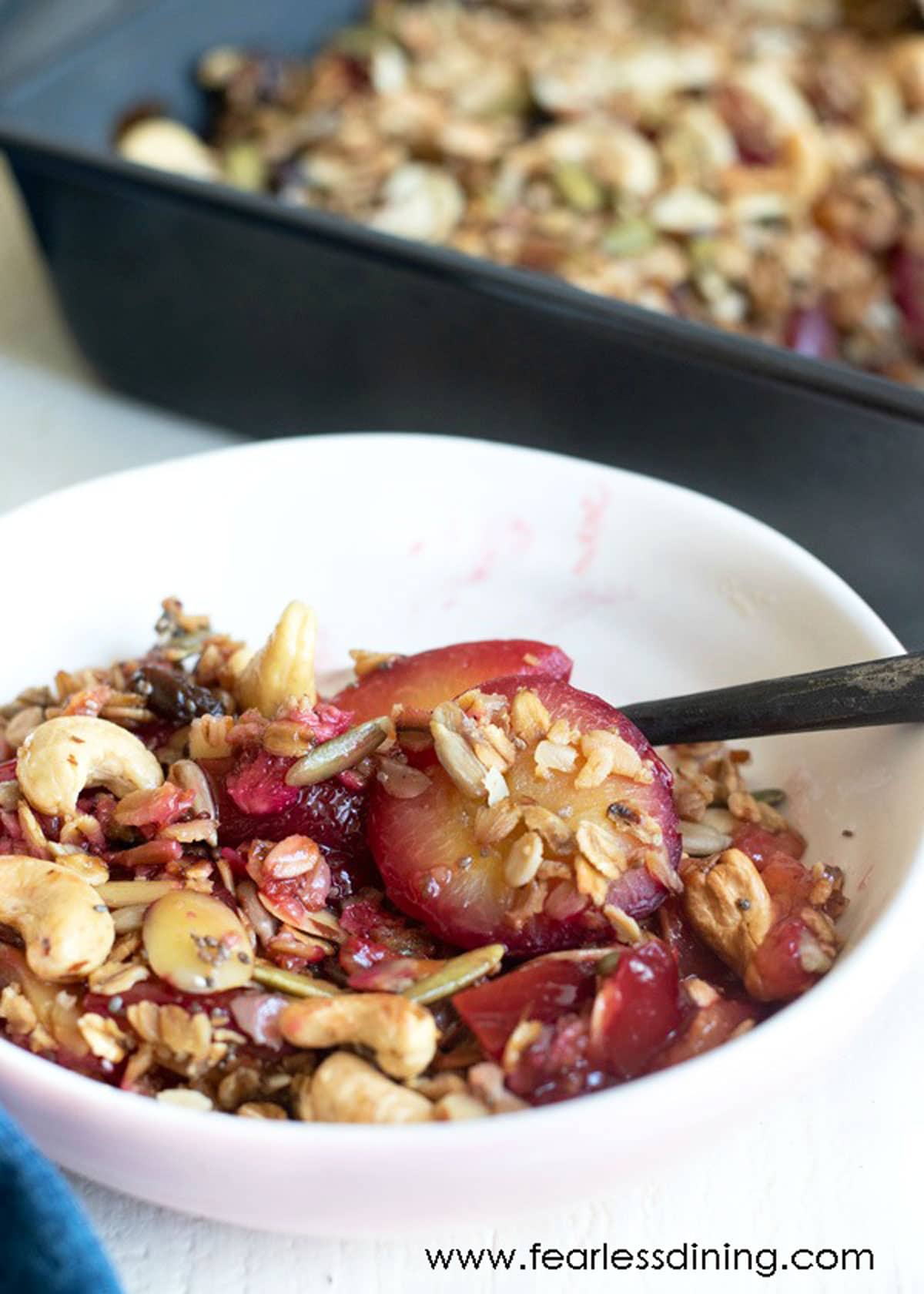 A white bowl filled with plum crisp.