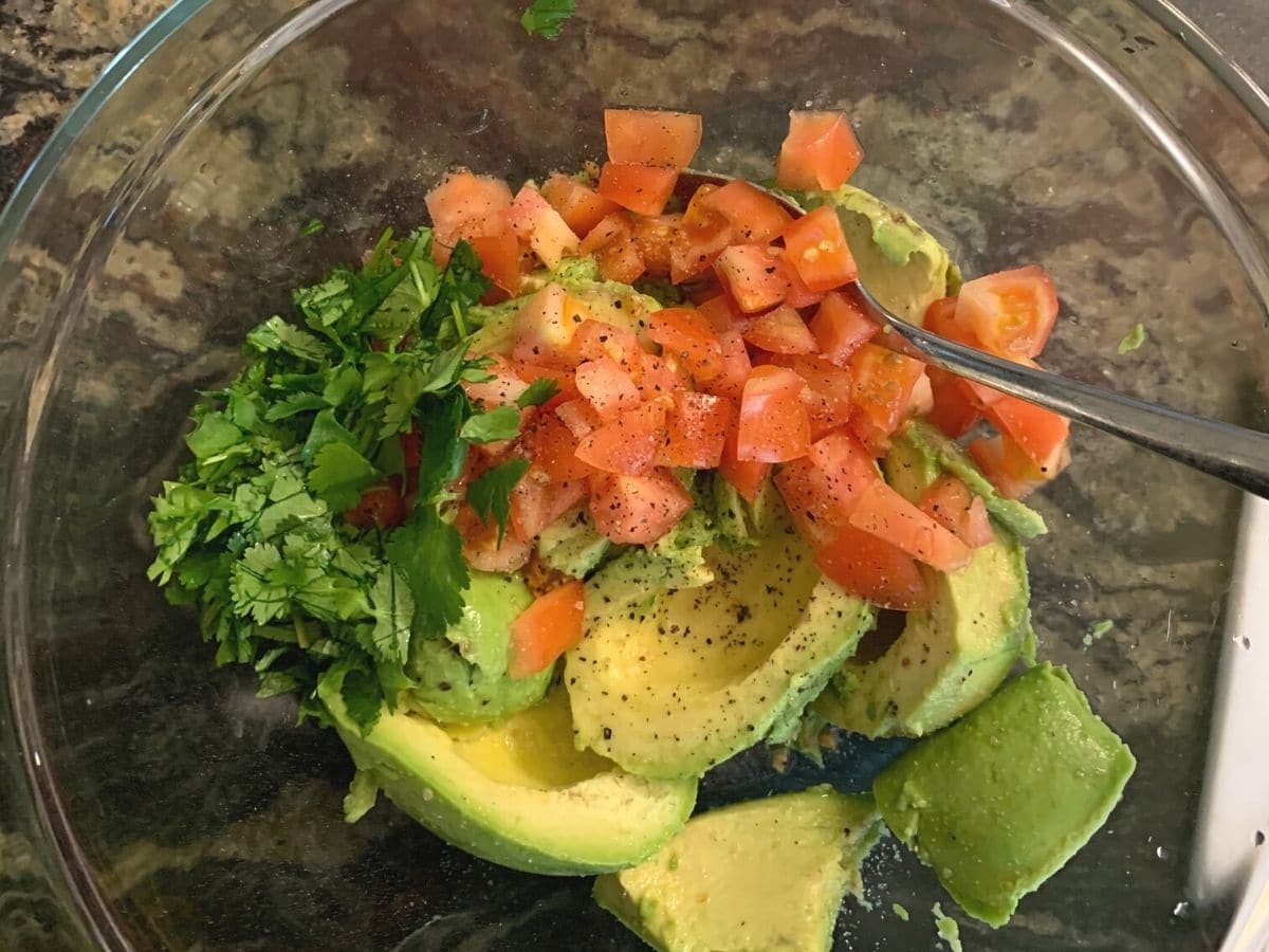 Guacamole ingredients in a large glass bowl.
