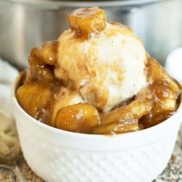 A white bowl filled with ice cream and caramelized bananas.