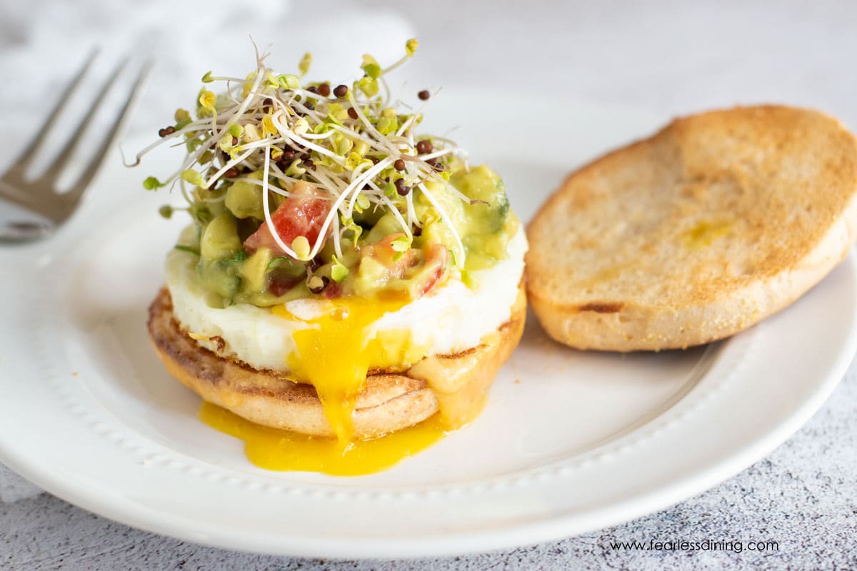 A gluten free breakfast sandwich on a white plate.