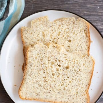 Two slices of gluten free bread machine bread on a plate.