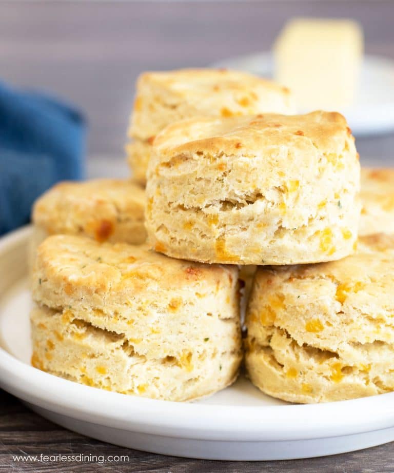 A big stack of gluten free cheddar biscuits on a plate.