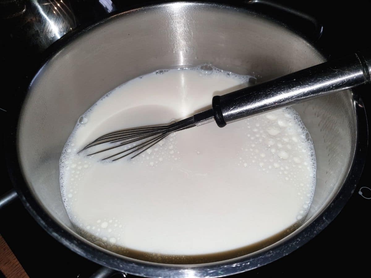 Heating milk and cheese in a pot.