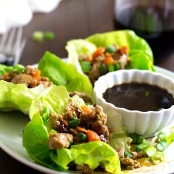 Gluten free lettuce wraps on a plate with sauce.
