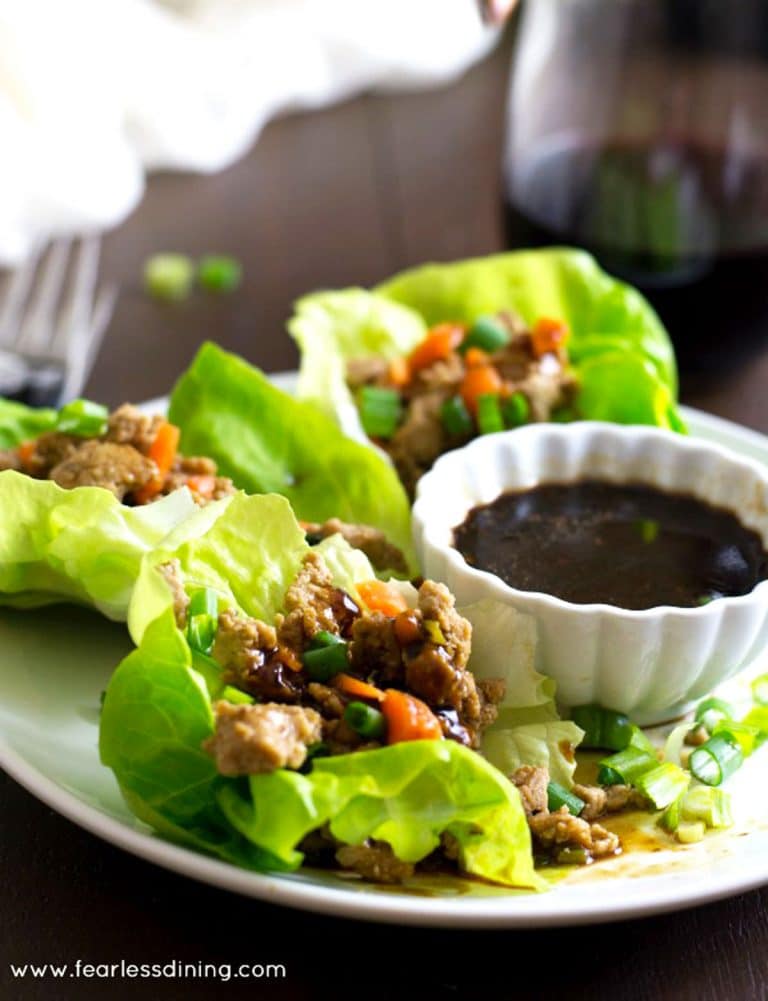 Gluten free lettuce wraps on a plate with sauce.