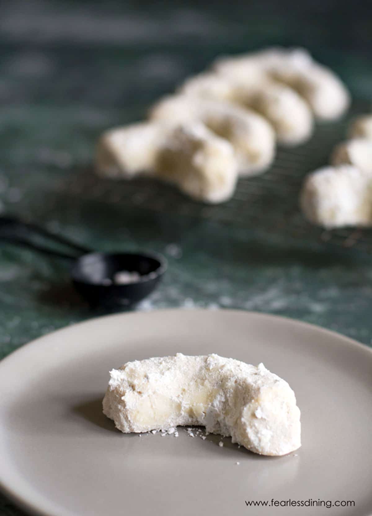 A vanilla crescent cookie on a small plate.