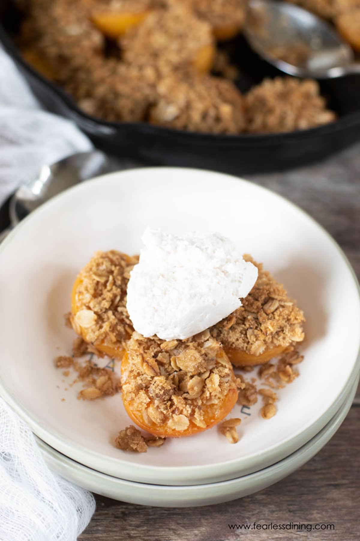 Gluten free apricot crisp topped with whipped cream.