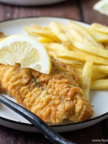 an air fried catfish filet on a plate with french fries