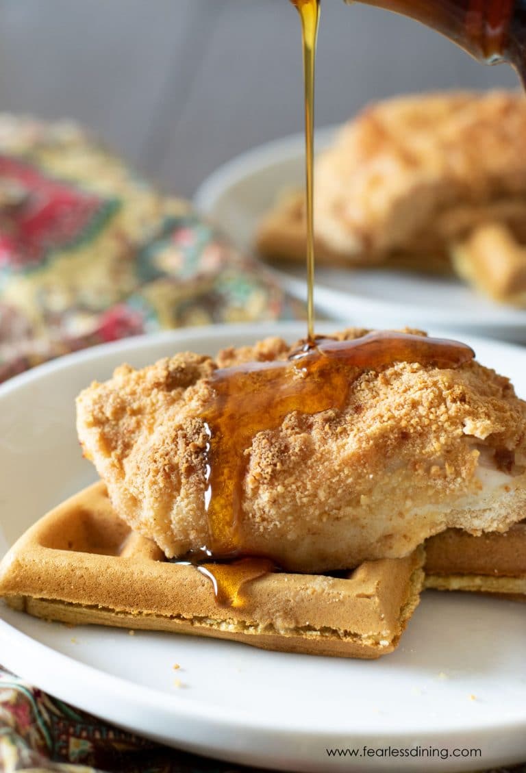 Pouring syrup over chicken and waffles.