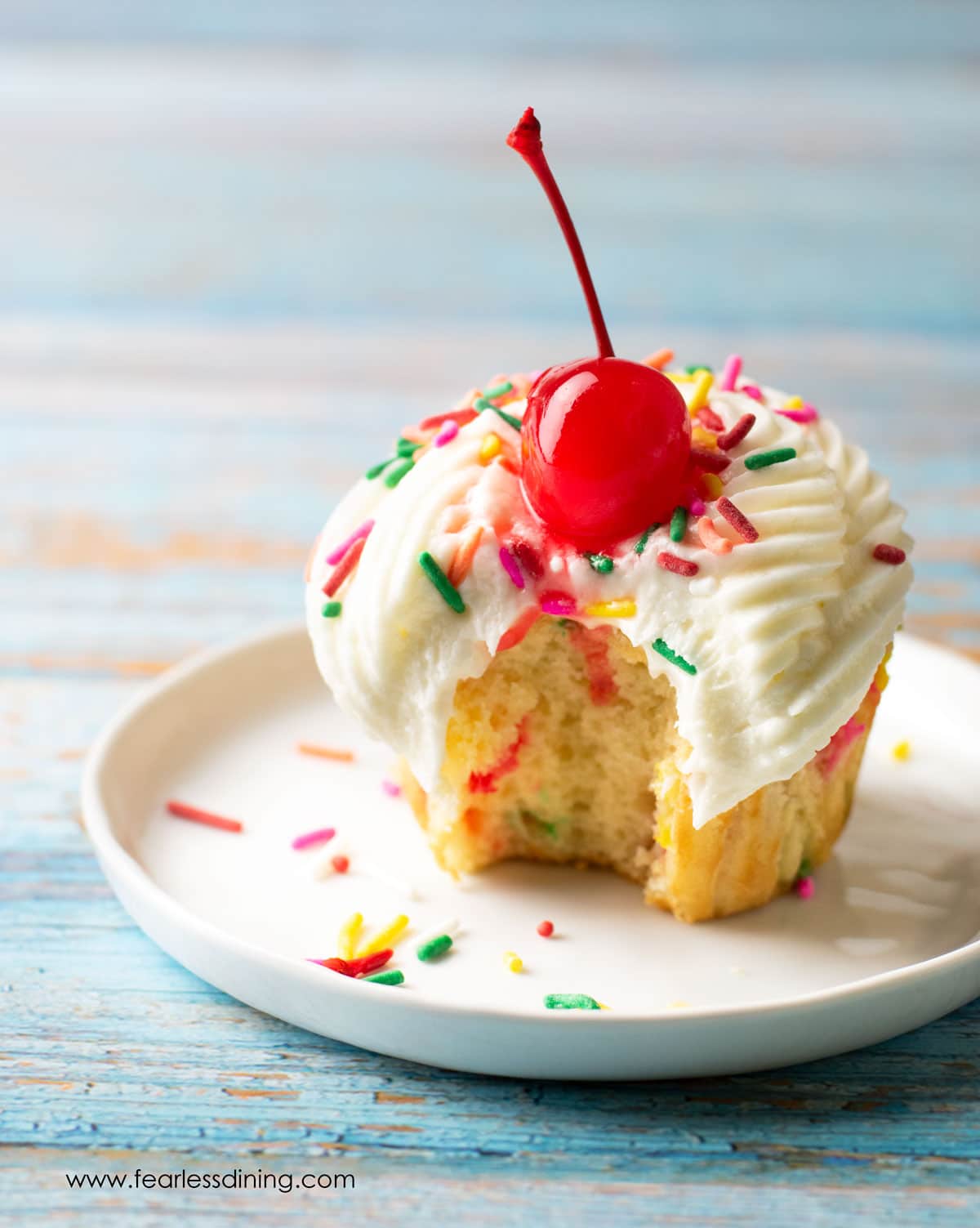 A funfetti cupcake with a bite taken out.
