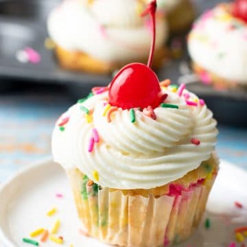 A gluten free funfetti cupcake on a small white plate.