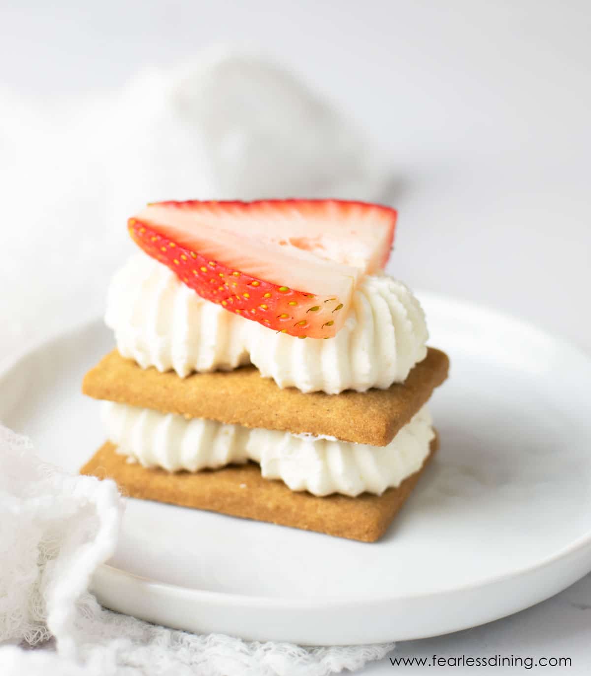 A single serving of a strawberry topped icebox cake.