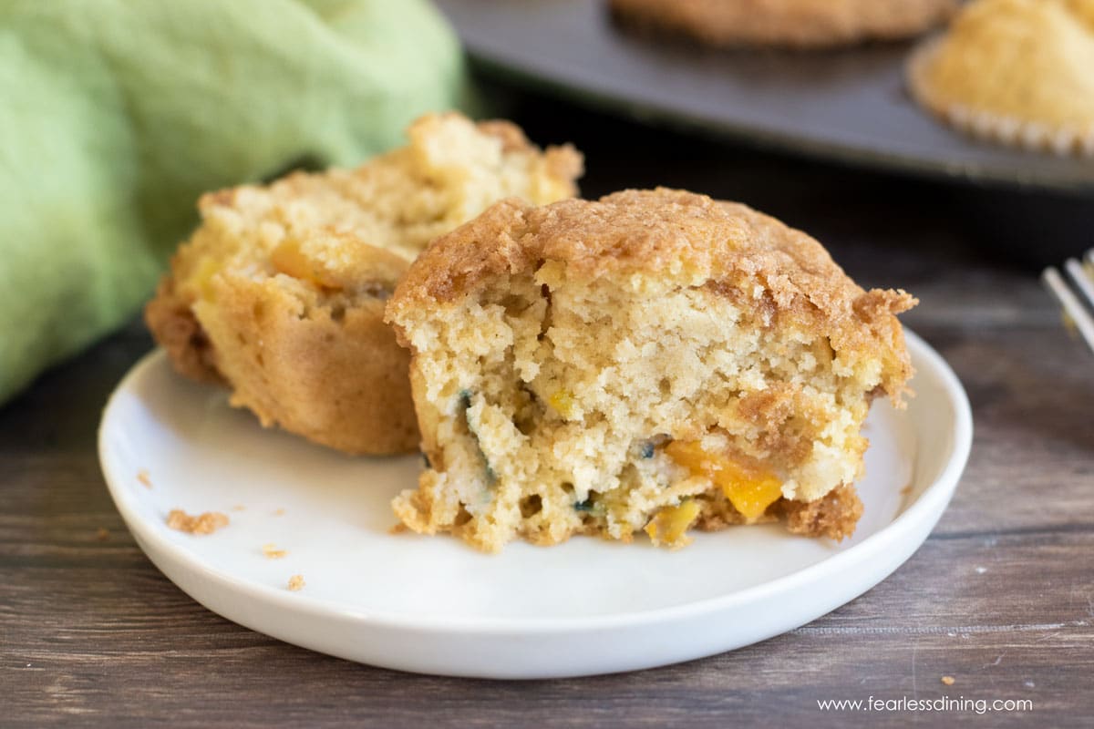 a peach muffin cut in half on a plate