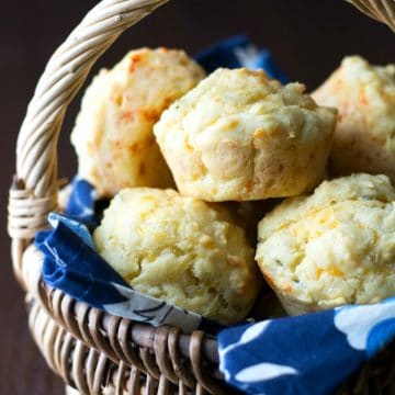 A basket filled with gluten free cheese muffins.