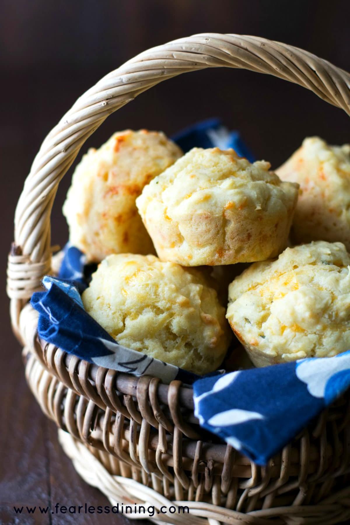 A basket filled with gluten free cheese muffins.