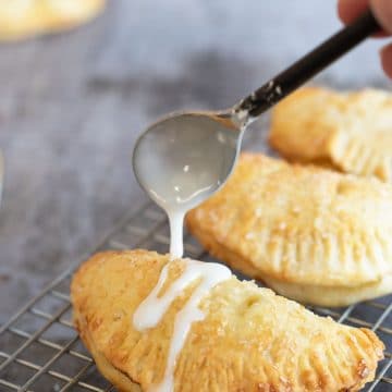 Drizzling icing over a gluten free air fried hand pie.