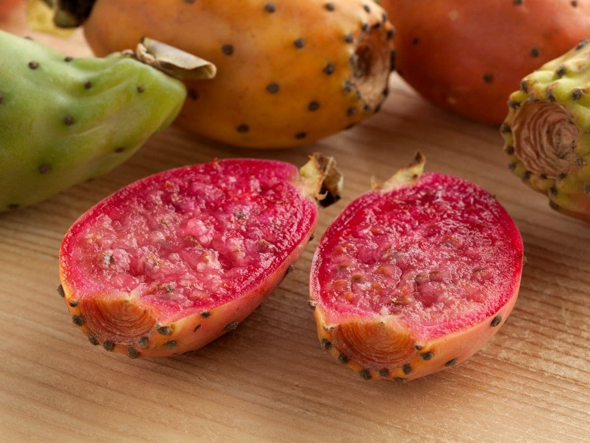 A cut prickly pear on a cutting board.