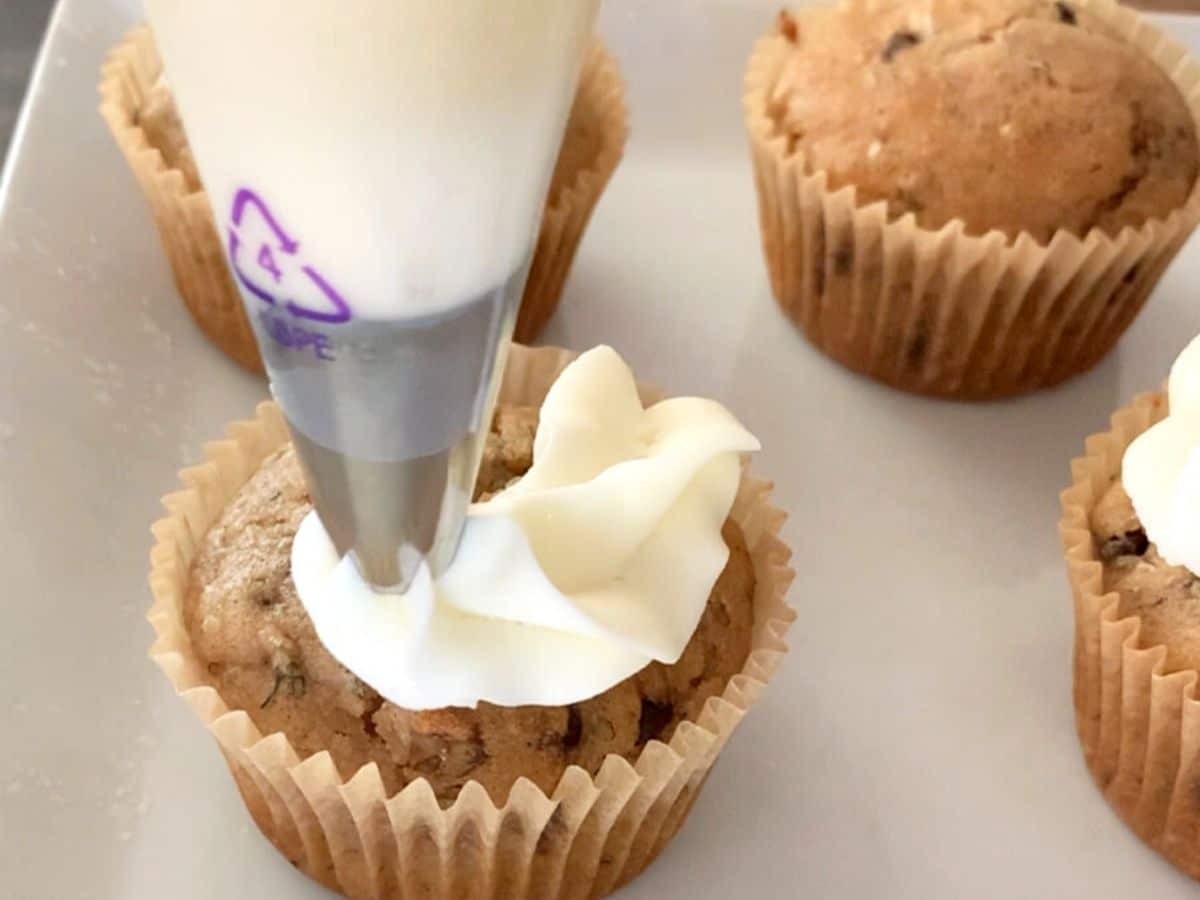 Piping frosting the cupcake with buttercream frosting