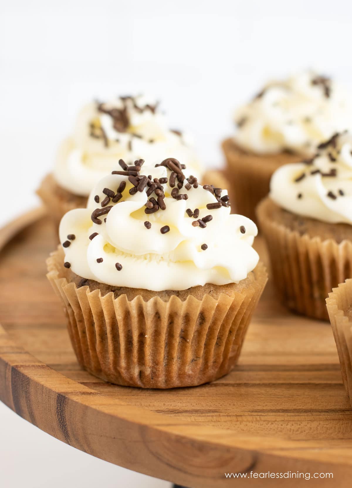 Gluten free banana cupcakes on a wooden tray.