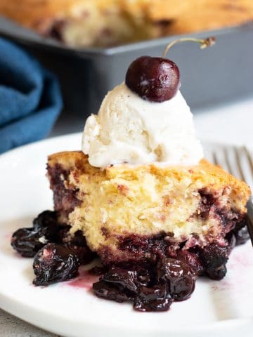 a serving of gluten free cake mix cherry cobbler topped with vanilla ice cream
