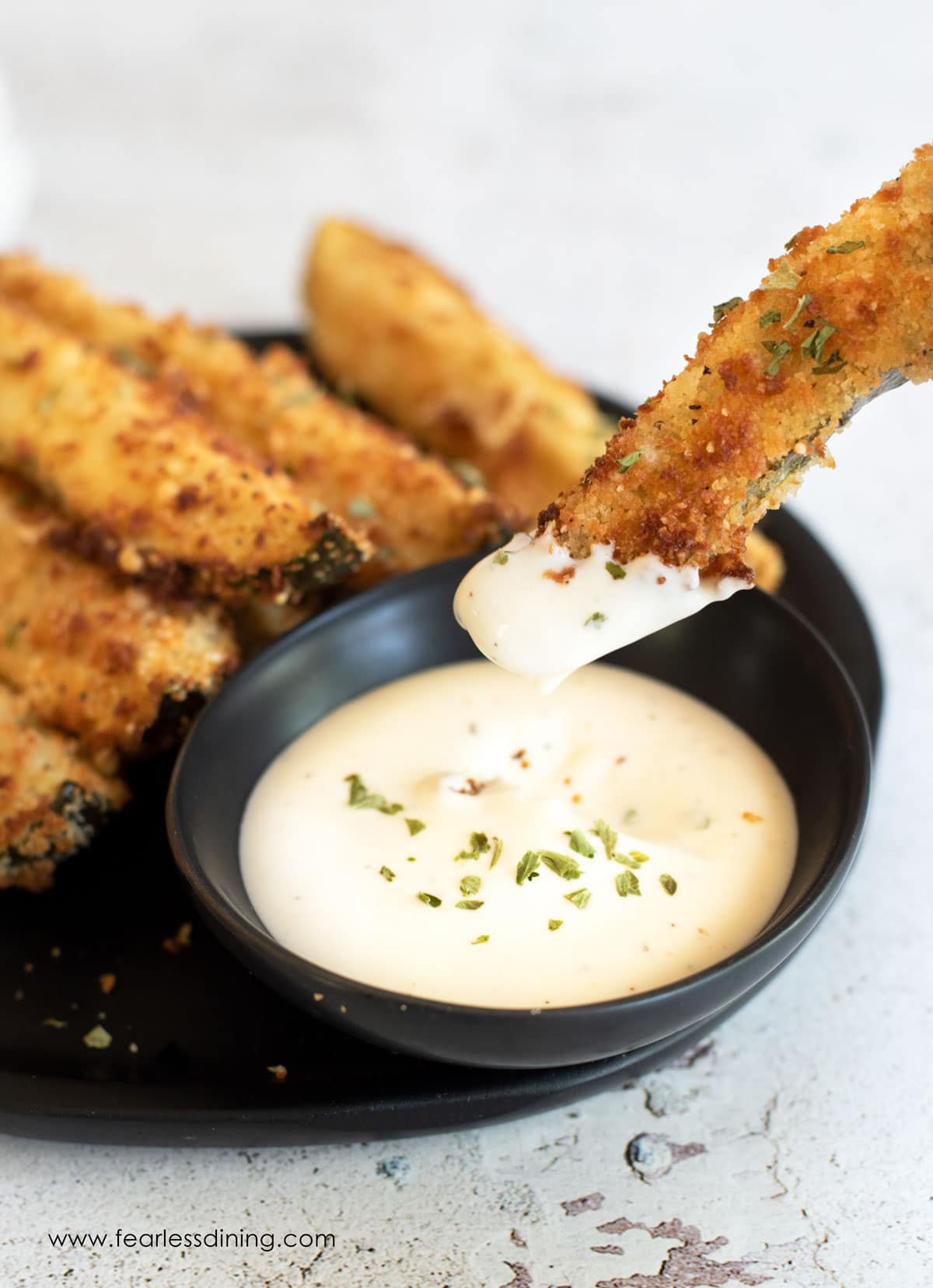 Dipping a fried pickle in ranch dressing.