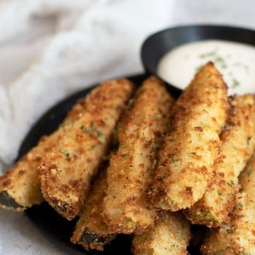 A platter of gluten free fried pickles and ranch dressing.