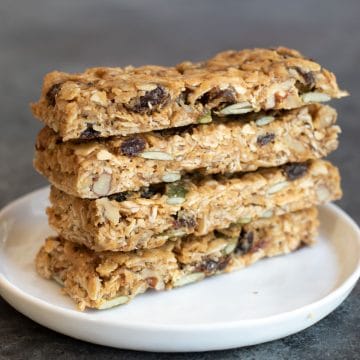 A stack of four gluten free granola bars on a white plate.