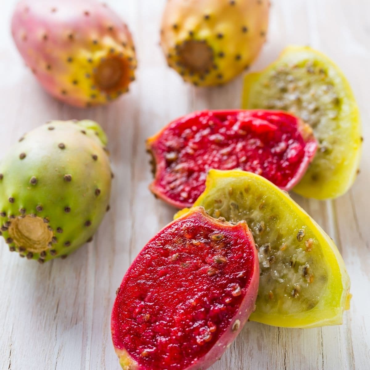 Cut prickly pears on a cutting board.