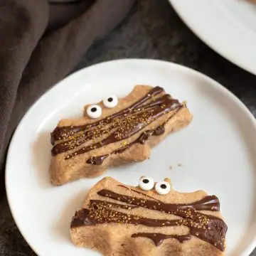 two bat shaped pumpkin shortbread cookies on a plate