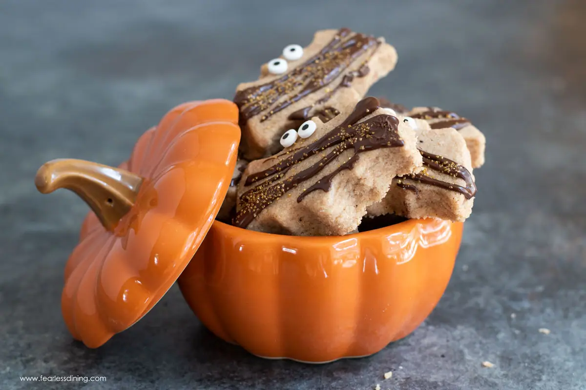 a pumpkin shaped container filled with pumpkin shortbread cookies