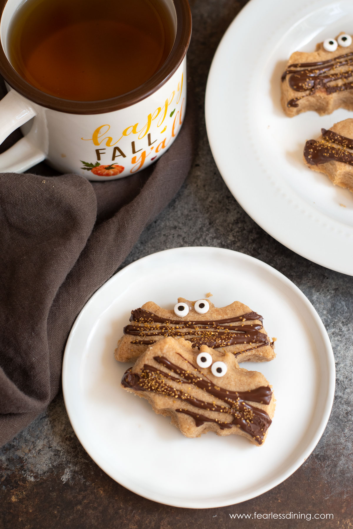 The top view of two bat shaped pumpkin spice shortbread cookies on a plate.