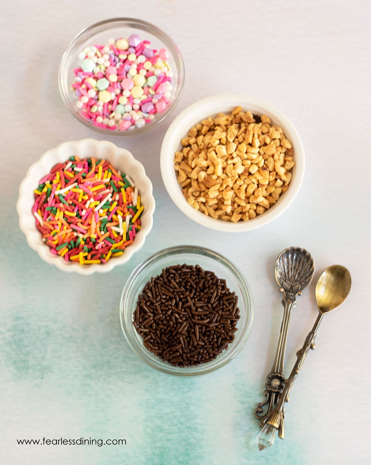 Toppings bar with dishes of sprinkles and chopped nuts.