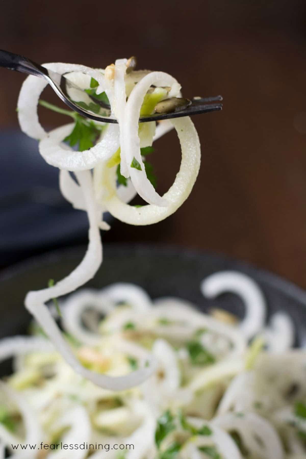 A fork full of daikon salad spirals.
