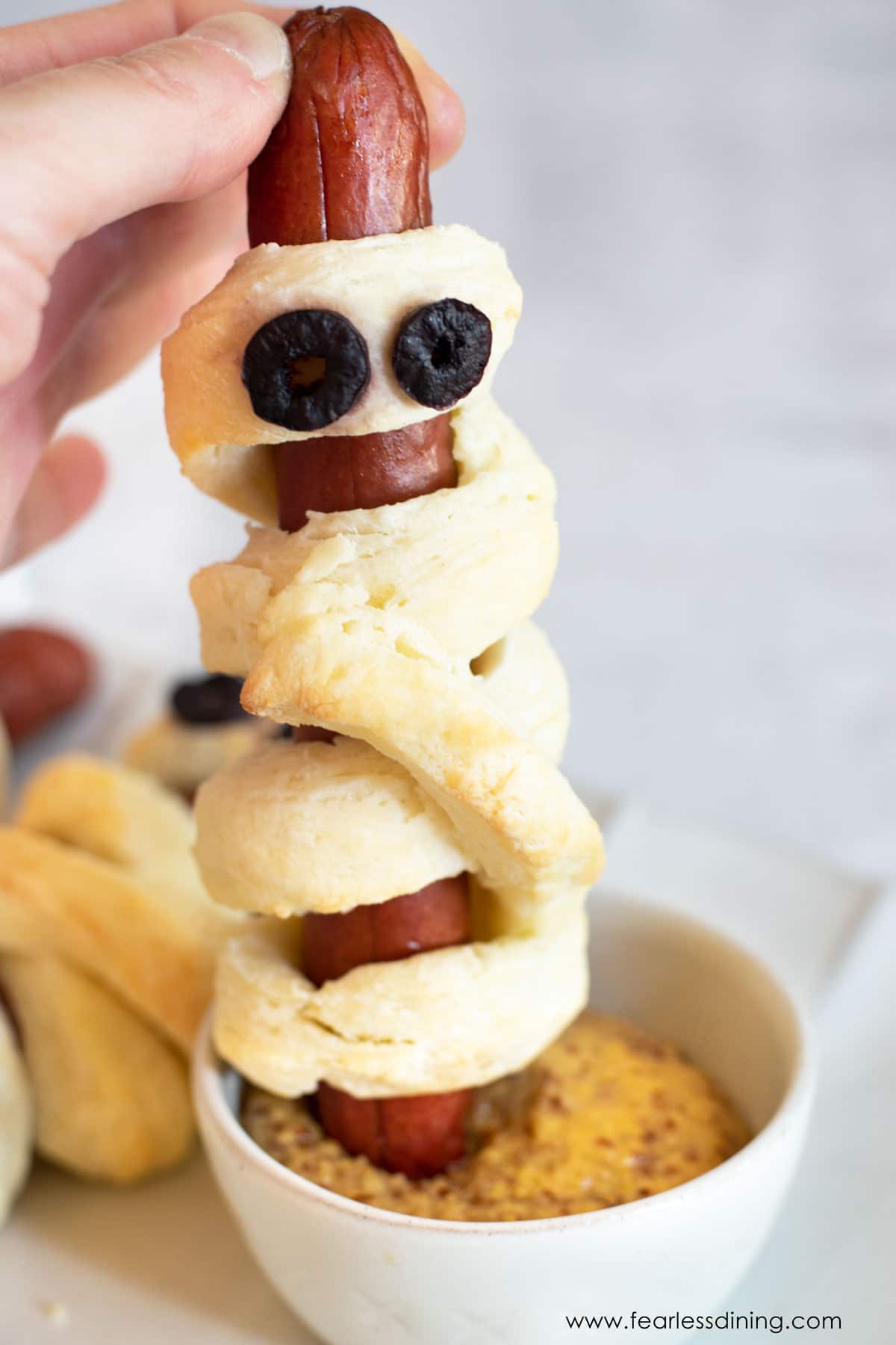 Dipping a pig in blanket in mustard.