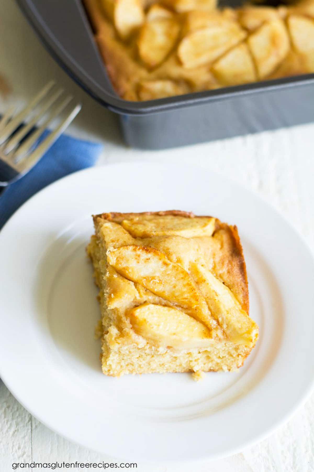A slice of gluten free German apple cake on a small white plate.