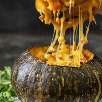 Lifting the top off a roasted stuffed kabocha squash.